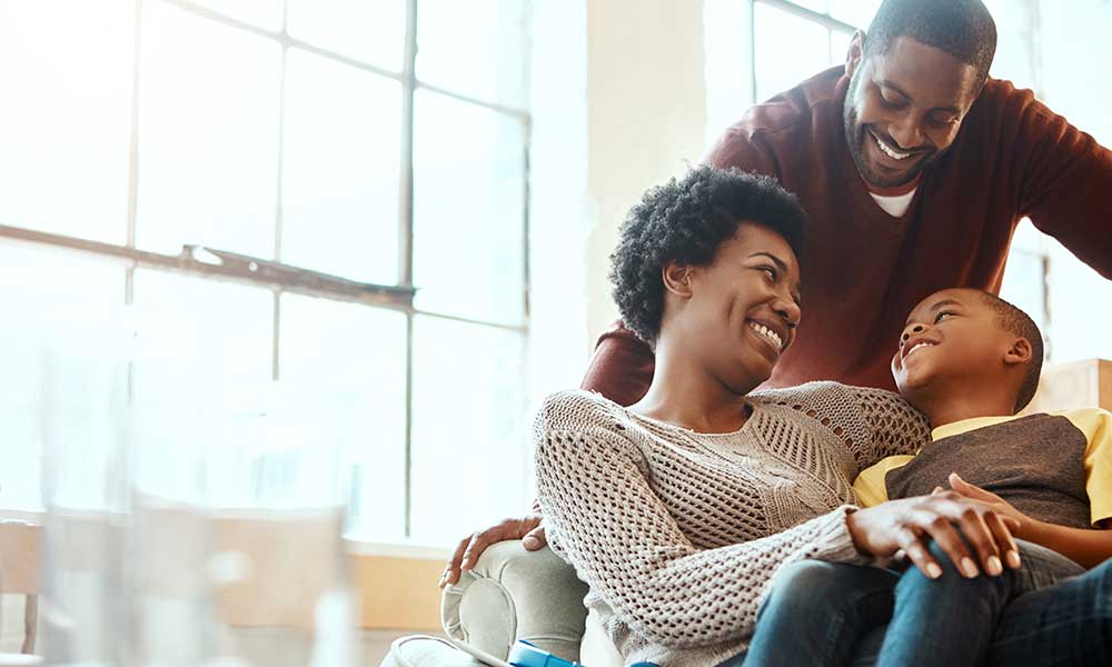mother and father smiling with their young son