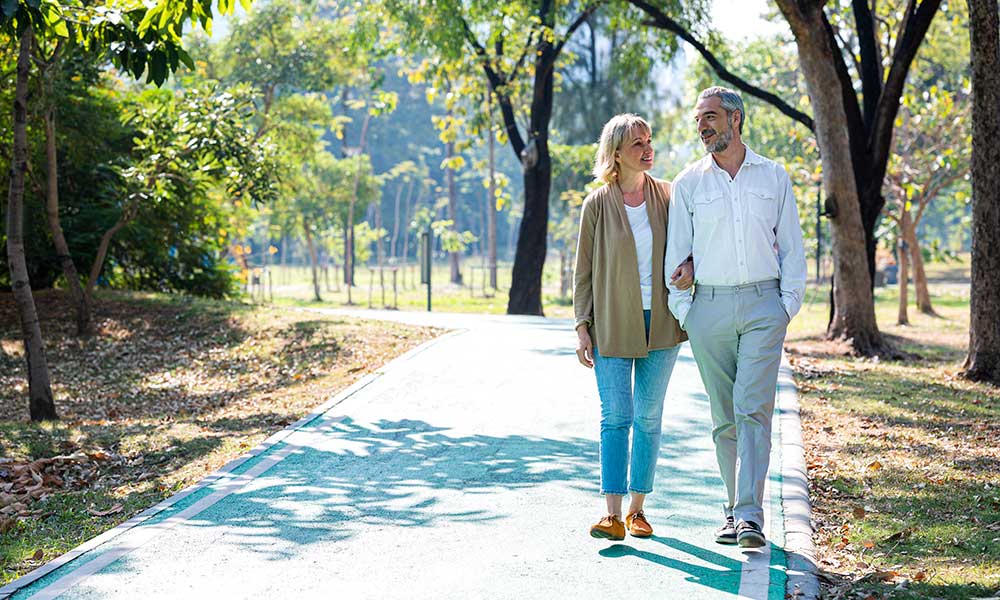 senior citizens taking a walking in a park during summer morning