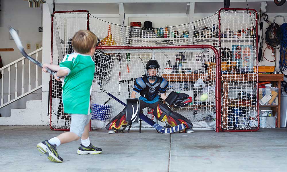 Boys playing hockey in garage