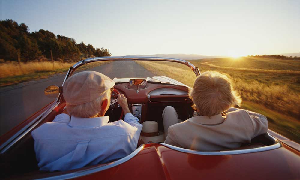 older couple in car with top down on nice day