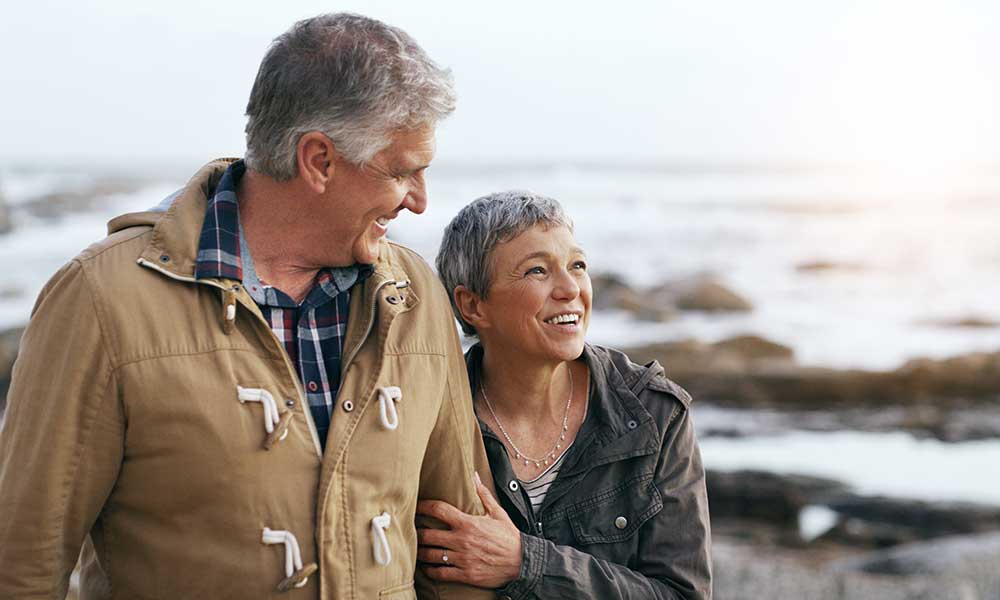 elderly couple taking a walk at the beach
