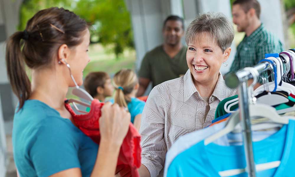 Ladies shopping together for clothing at garage sale