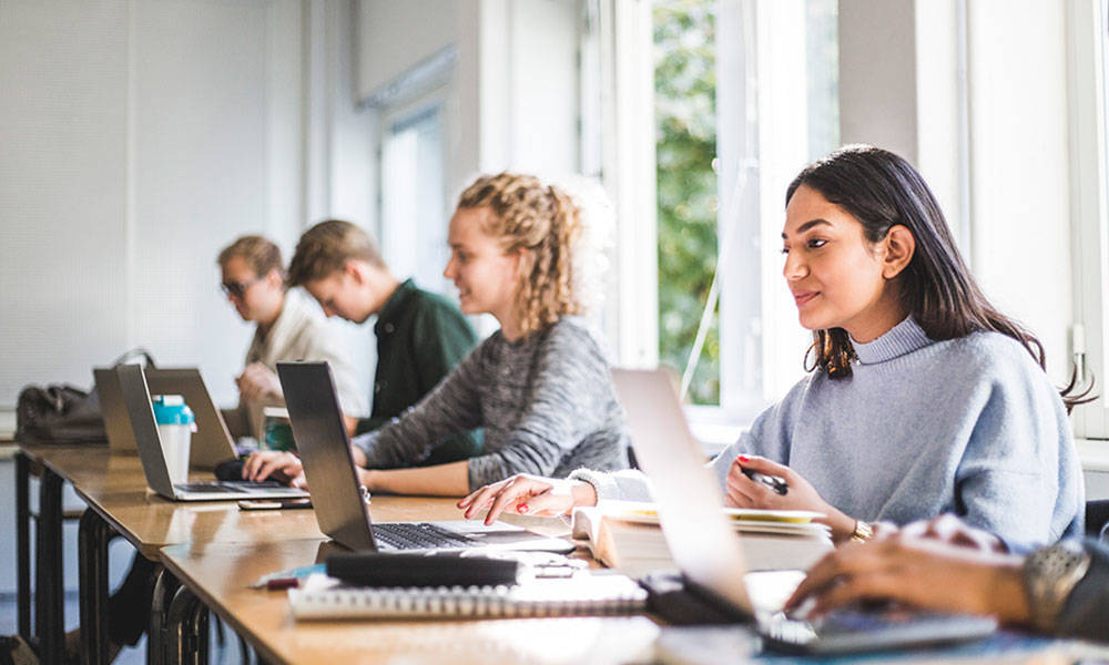 college students using laptops in classroom