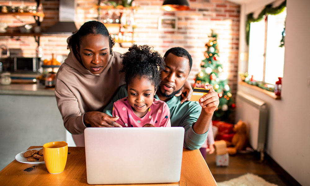 young family of 3 doing some online Christmas shopping
