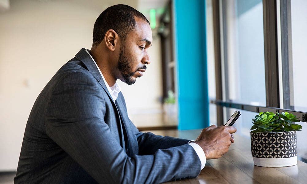 businessman checking mobile device in office