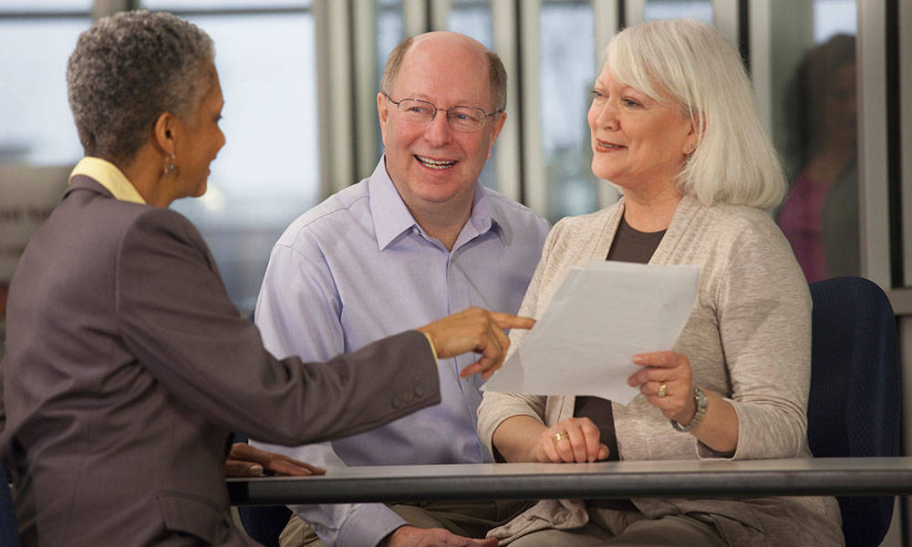 older couple speaking with financial advisor in meeting