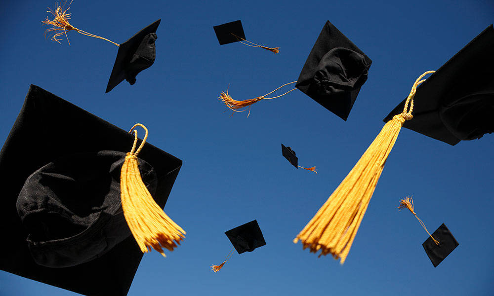 graduation caps thrown in the air