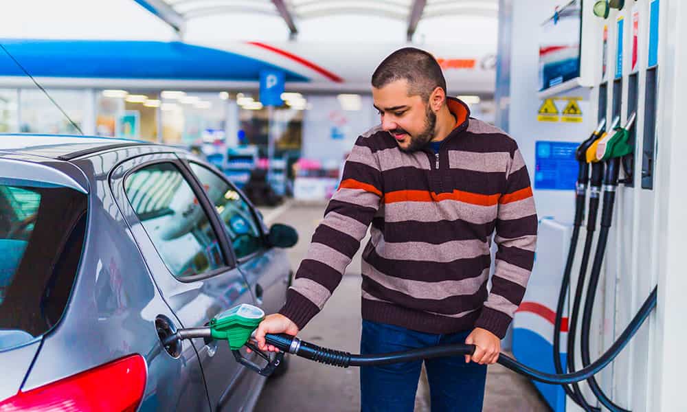 man filling up car at gas station