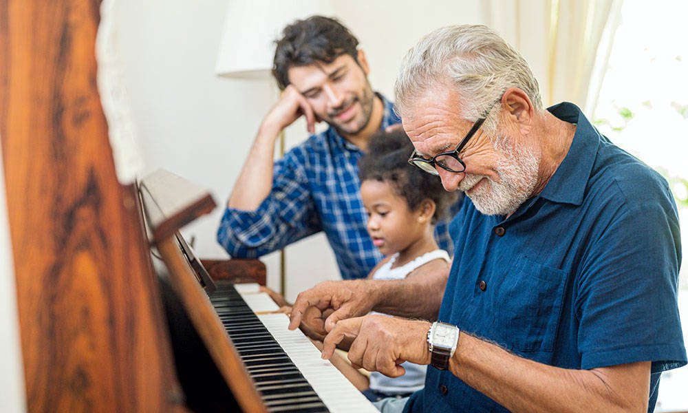 three generations of family sitting around the piano