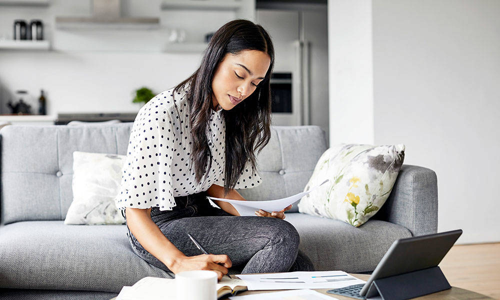 woman analyzing documents while sitting at home