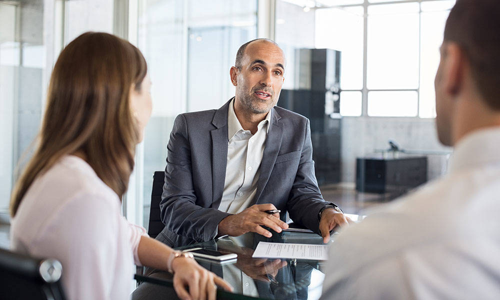 financial advisor discussing investments with young couple