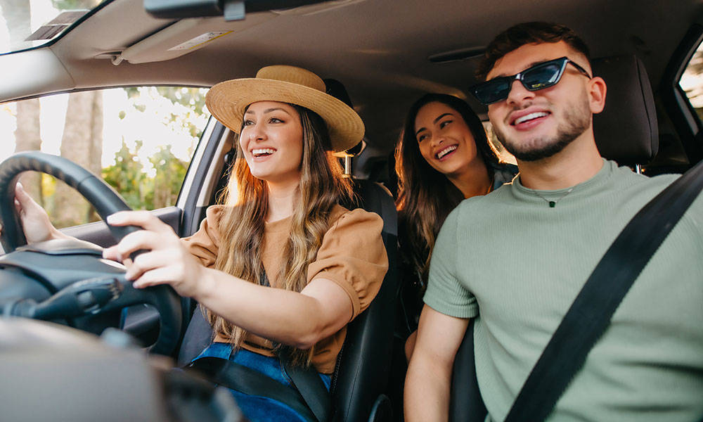 three friends laughing together in the car