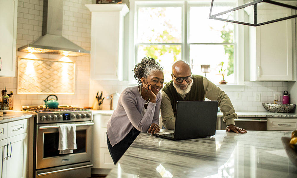couple looking at finances on computer in kitchen