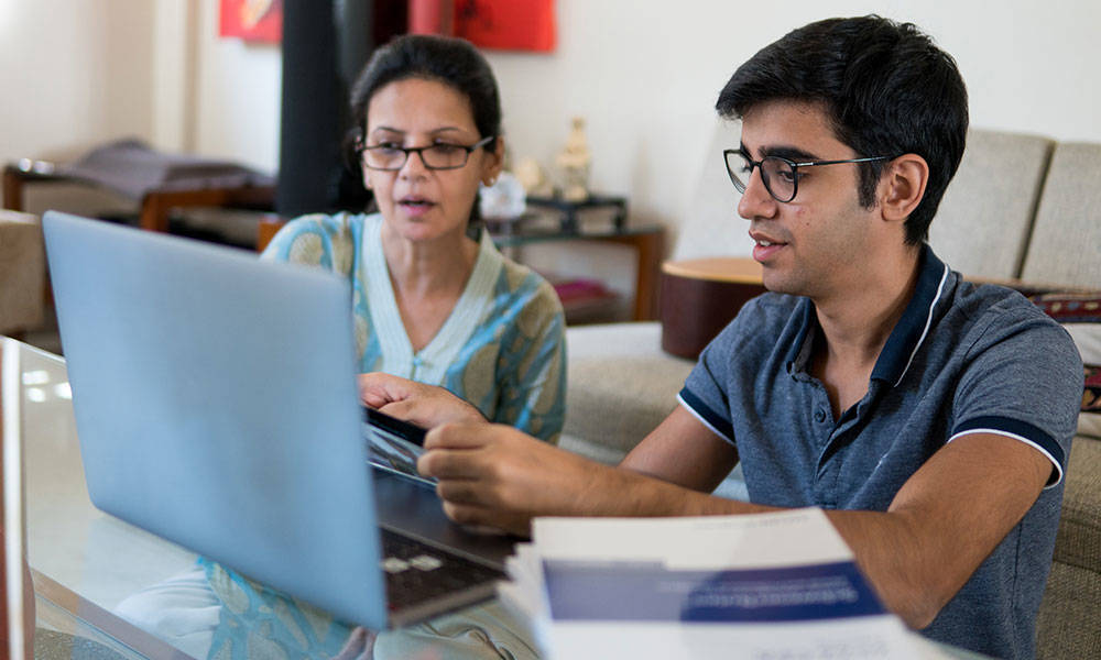 mother and son reviewing documentation on laptop