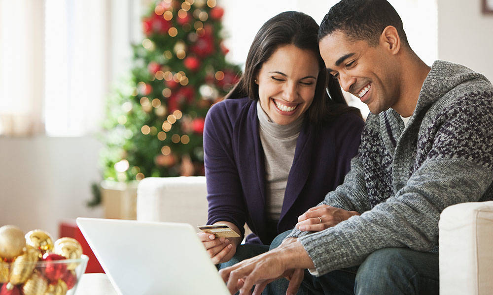 couple holding credit card and using laptop