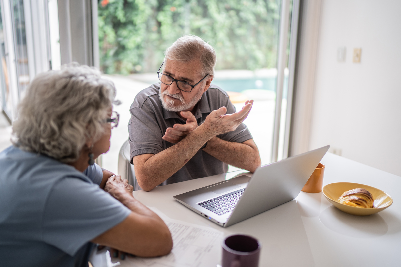 Couple talking finances at a computer