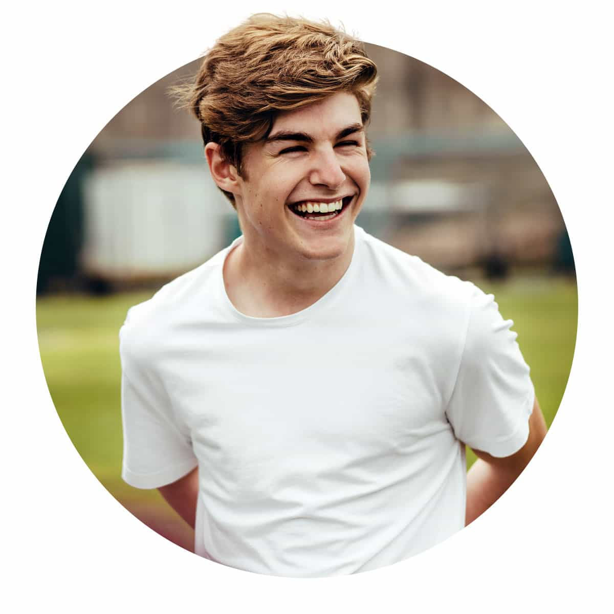 High School boy laughing with friends outside.