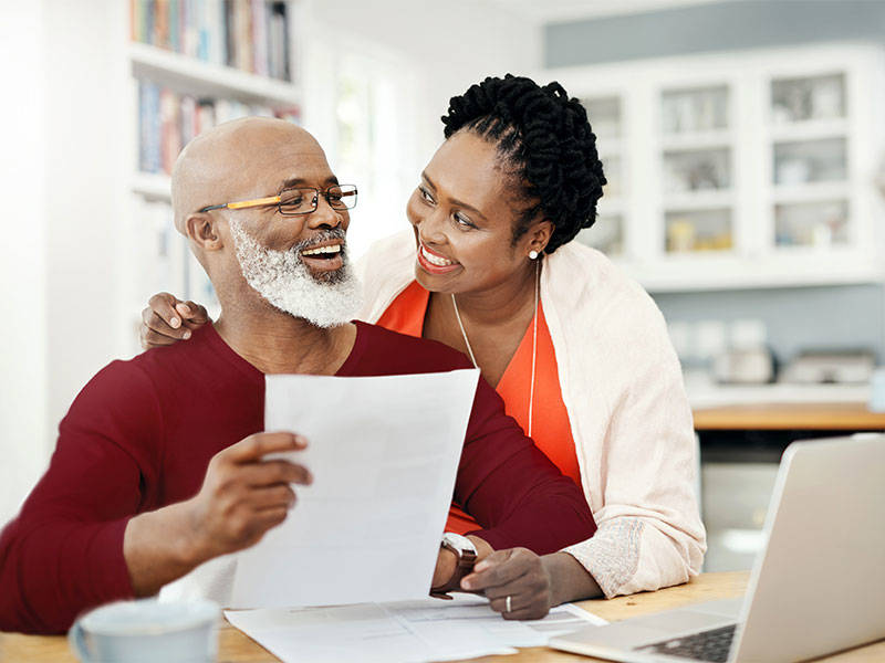 Mature couple managing their paperwork together at home.