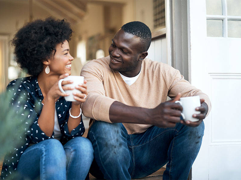 Happy young couple drinking coffee and spending time together outside.