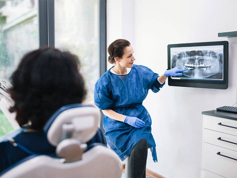 Female dentist explaining dental x-ray to a patient.