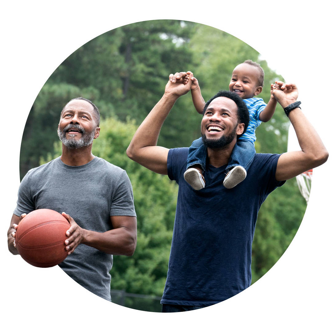 Grandfather, young father, and toddler happily playing basketball.