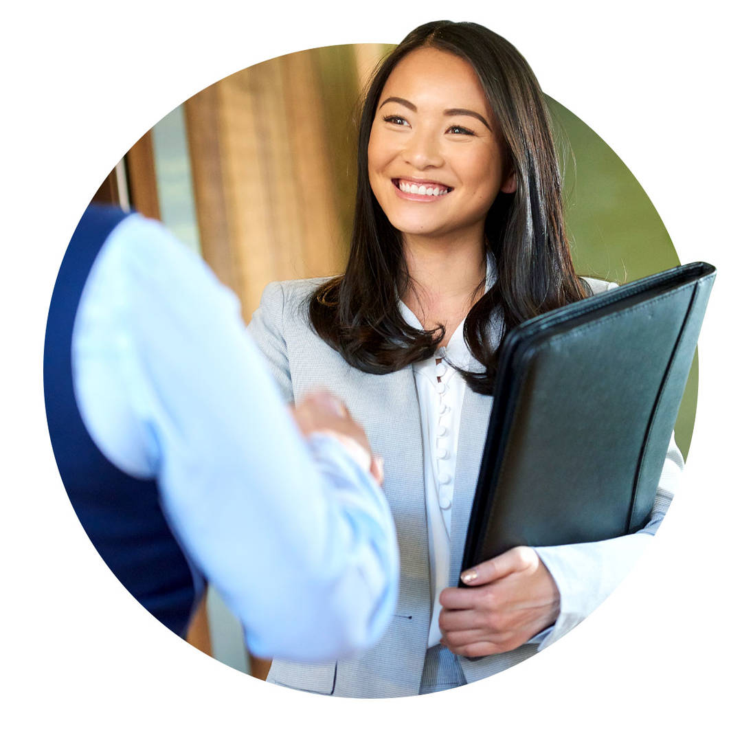 Businesswoman shaking hands with another colleague in an office.