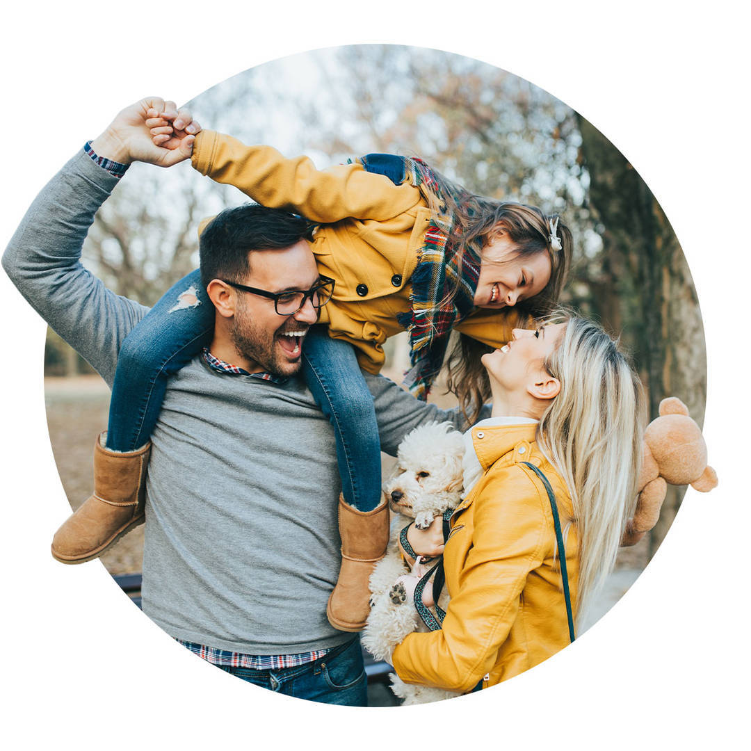 Happy family of three enjoying the fall season together at the park.