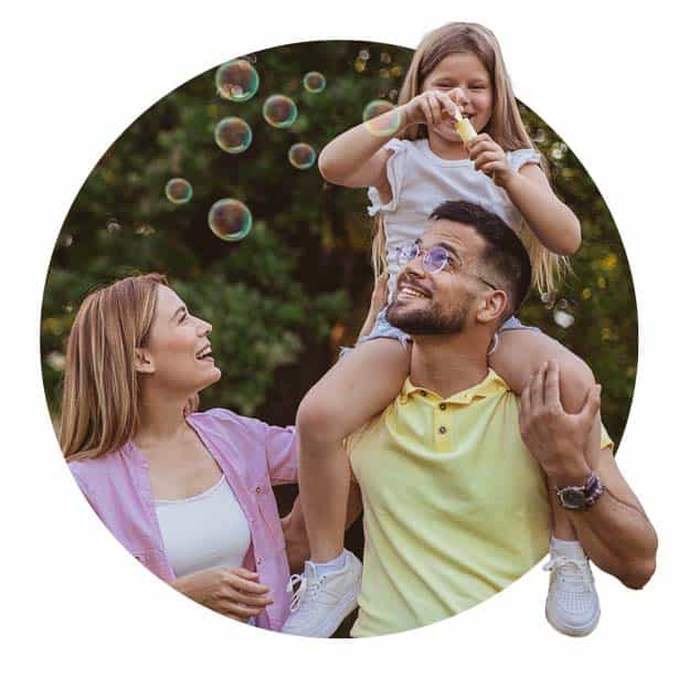 Family playing outdoors with bubbles in the Spring