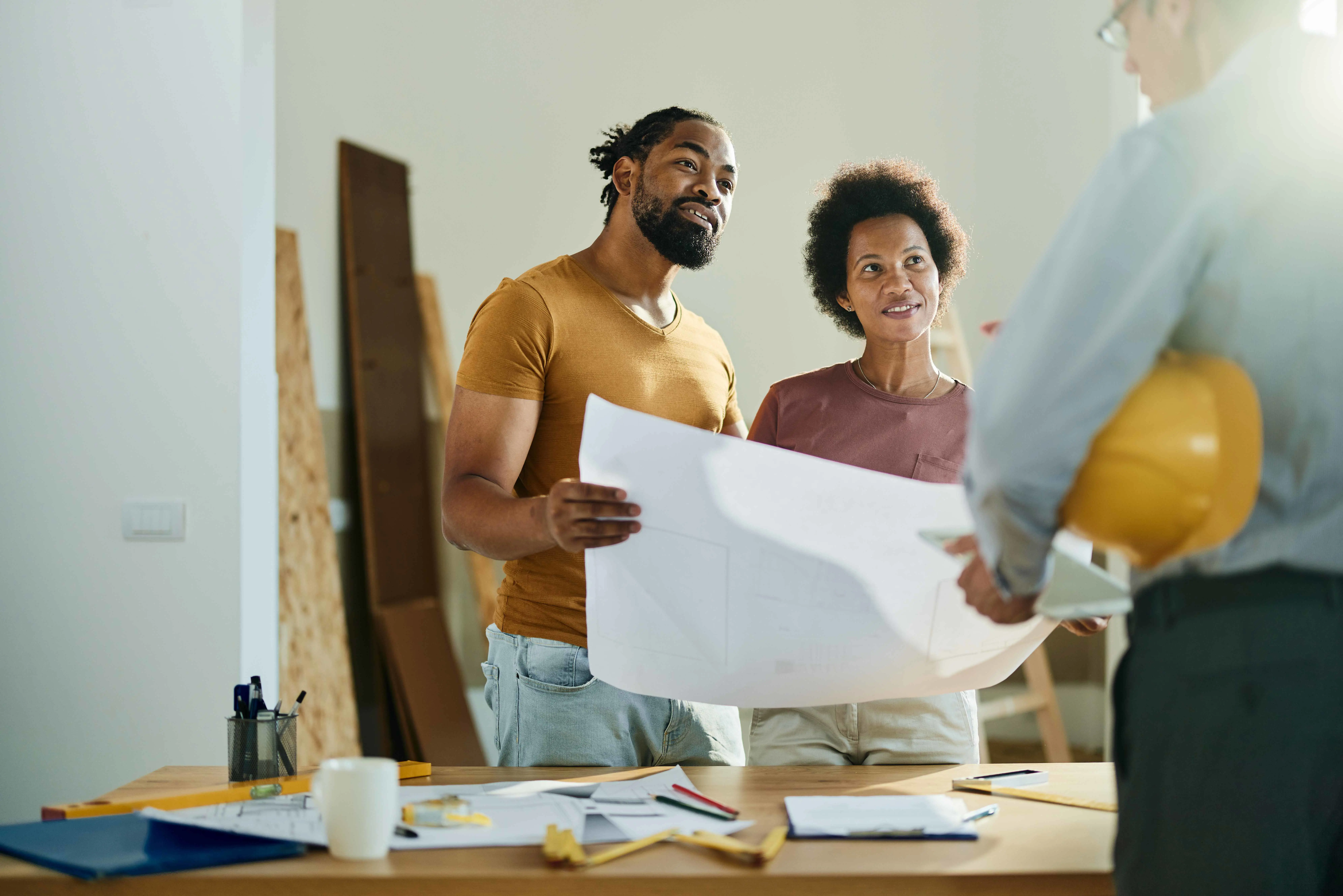  Happy black couple talking to real estate agent in the apartment.