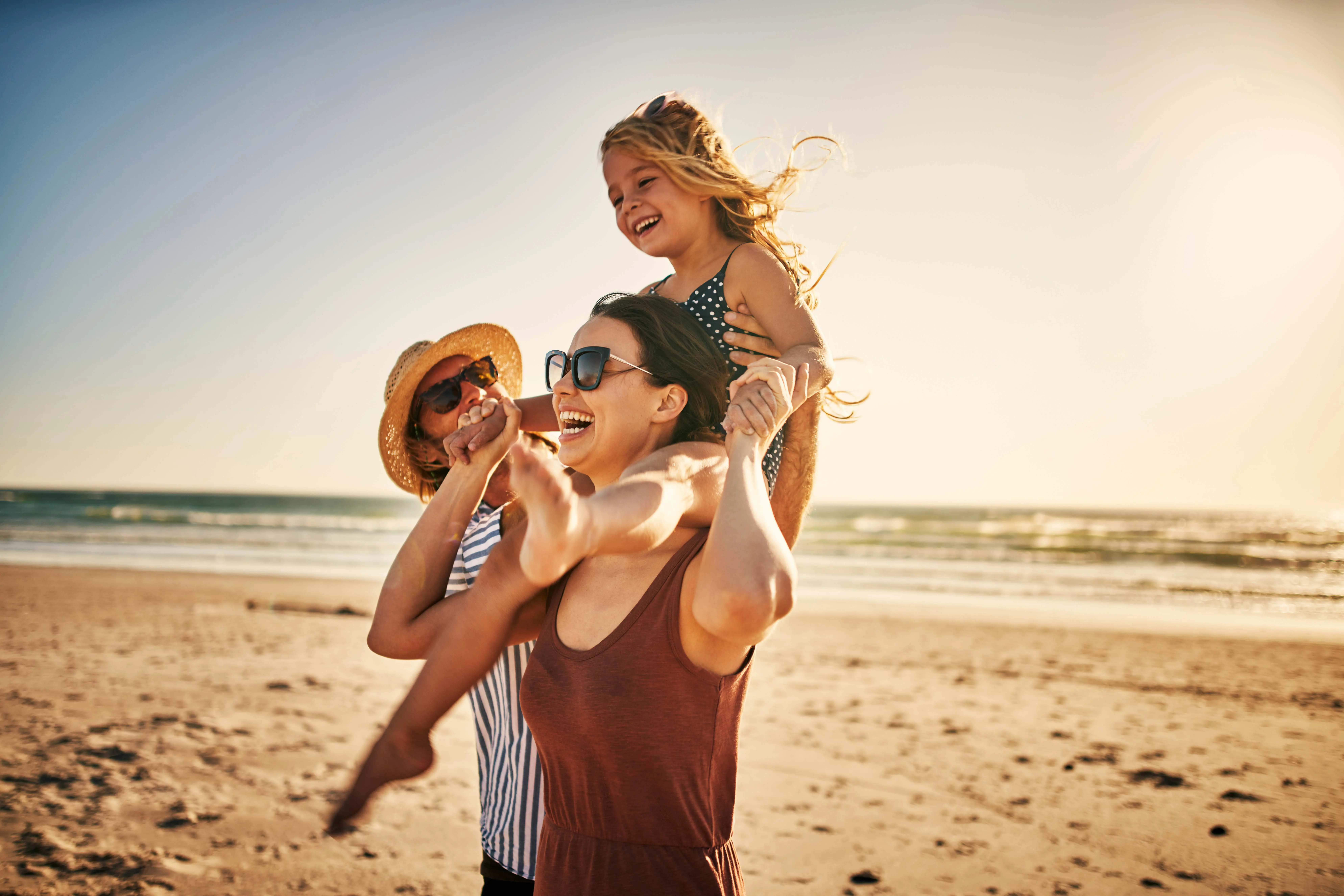 dorable little girl spending the day at the beach with her parents