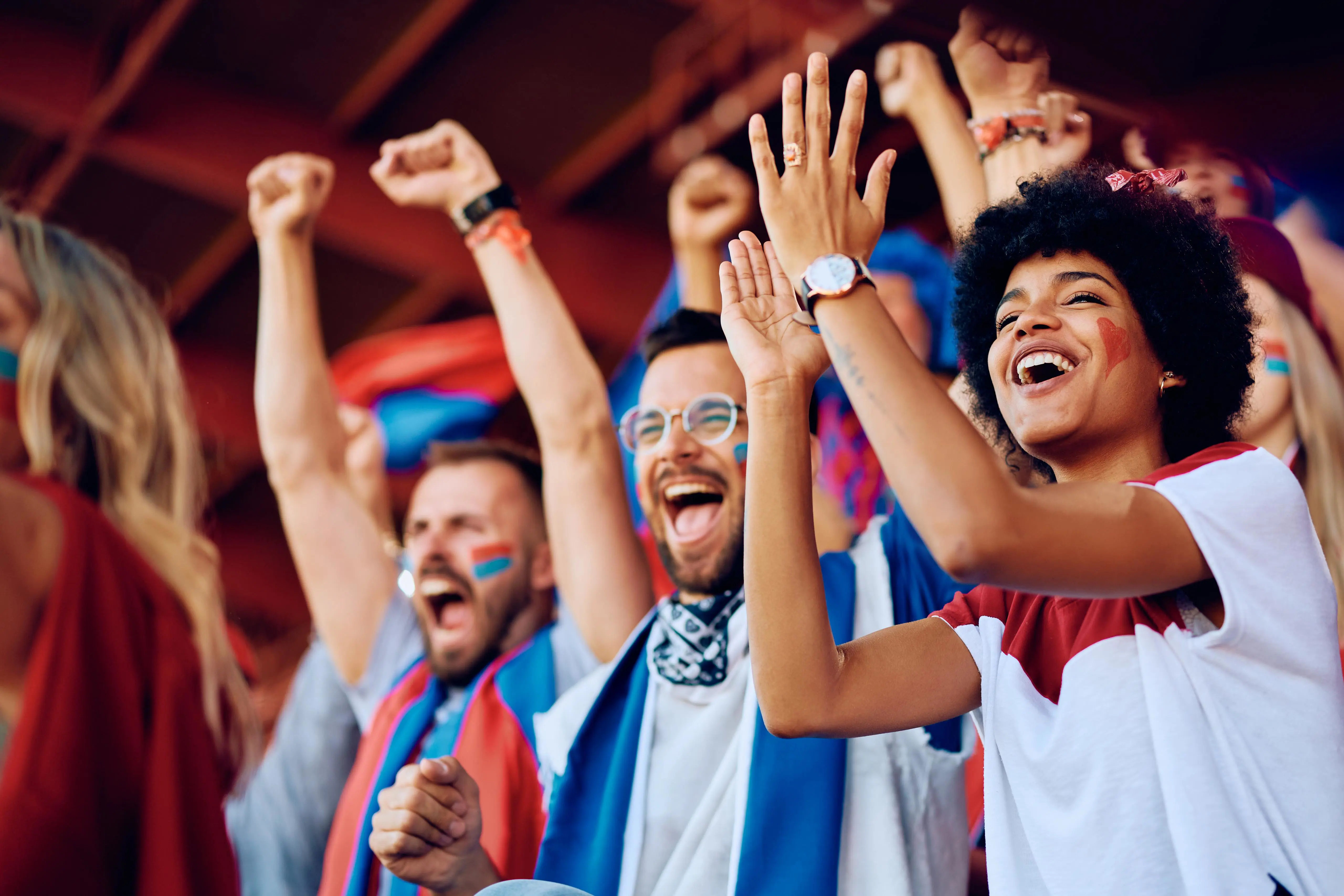 Soccer fans in blue and red are cheering