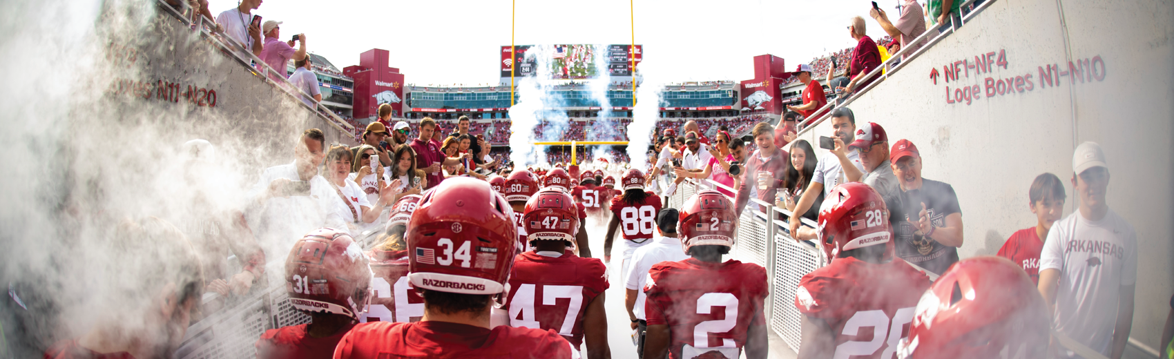University of Arkansas football team entering a packed stadium